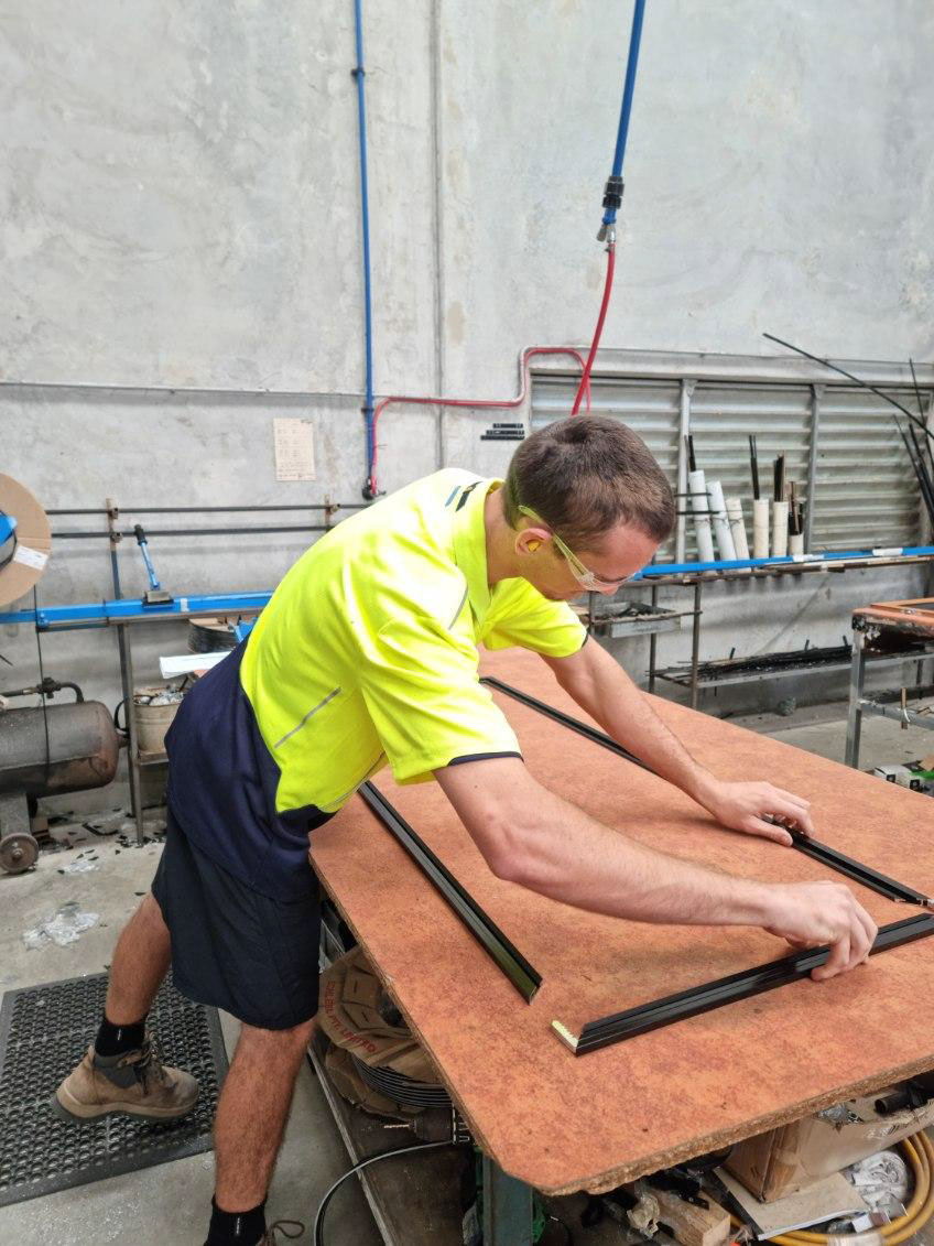 Aluminium frame sections being assembled and squared during the framing stage