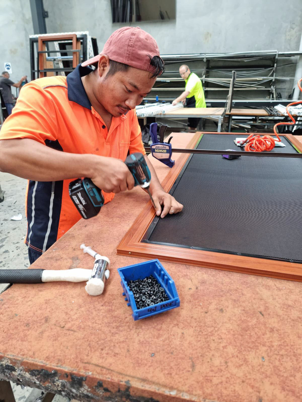 Crimsafe mesh being clamped and screwed into the aluminium frame during assembly