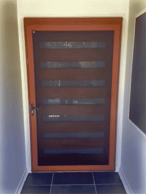 Crimsafe pivot door with woodgrain finish installed